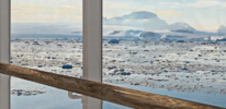 Aussicht aus Glasfront auf Eisflächen im Ozean