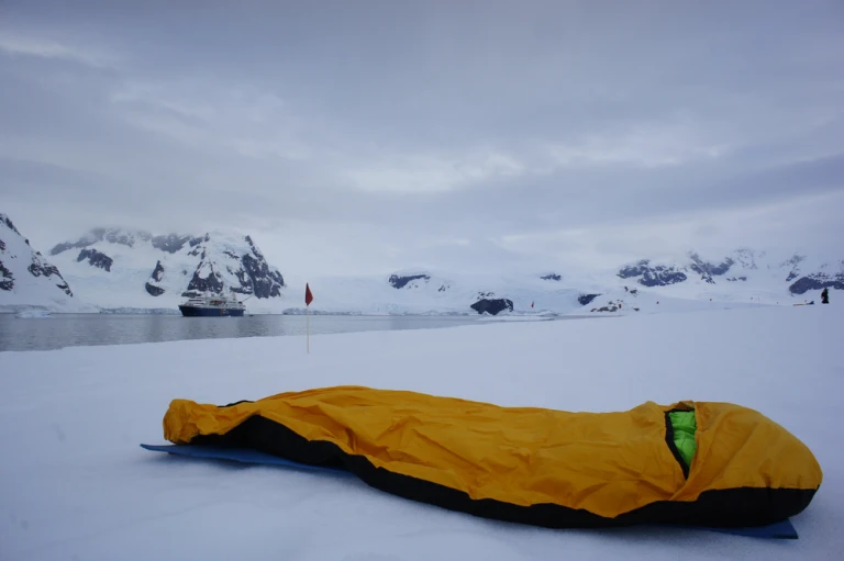 Man sieht einen gelben Schlagsack in der Antarktis beim beliebten Antarktis Camping