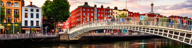 Dublin, Irland. Nachtblick auf die berühmte Ha Penny Bridge in Dublin, Irland bei Sonnenuntergang
