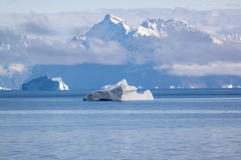 Grönland Eisberg im Ozean mit Küstenlandschaft